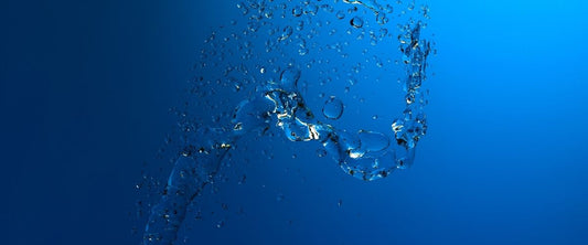 Chorro de agua sobre un fondo azul simulando squirting de una mujer